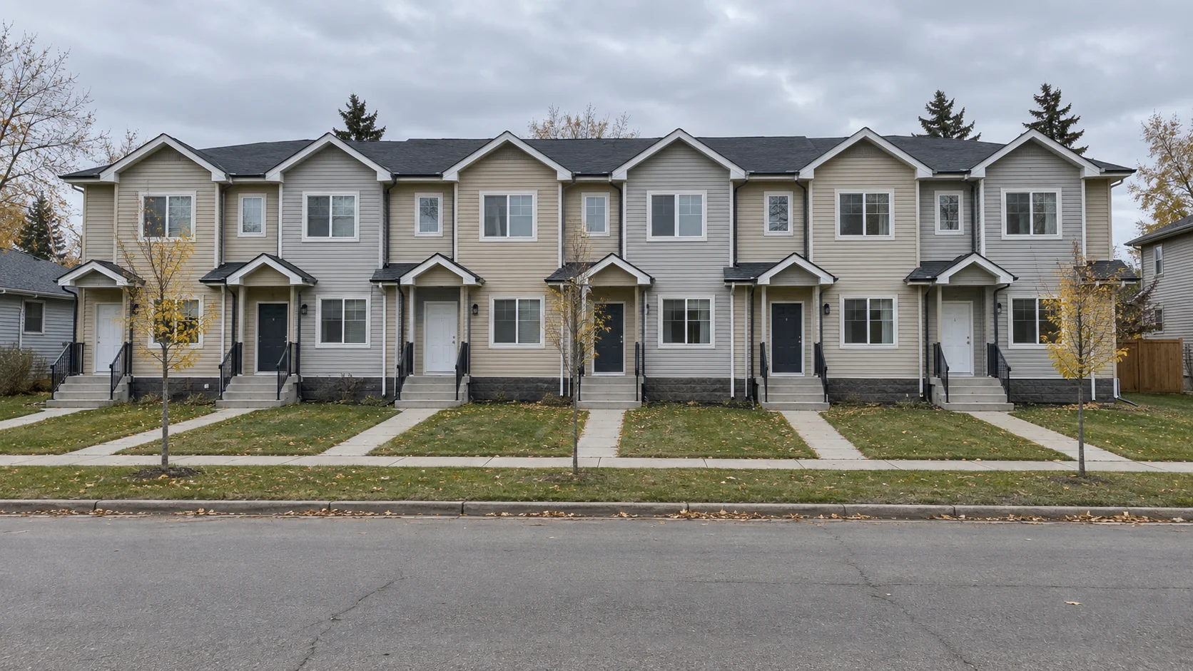 The finished six-home concept with simple beige siding and pitched roofs